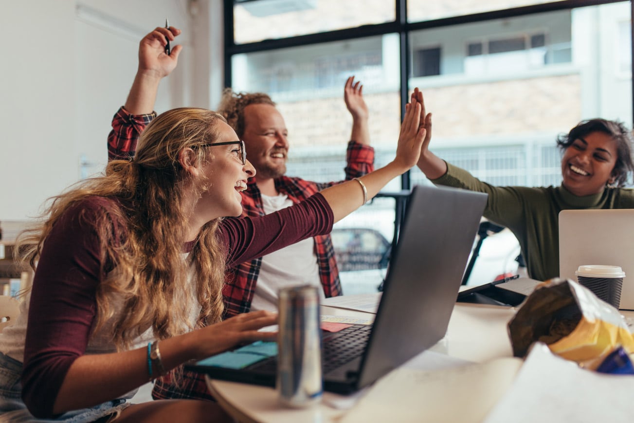 Team high fives after launching responsive website