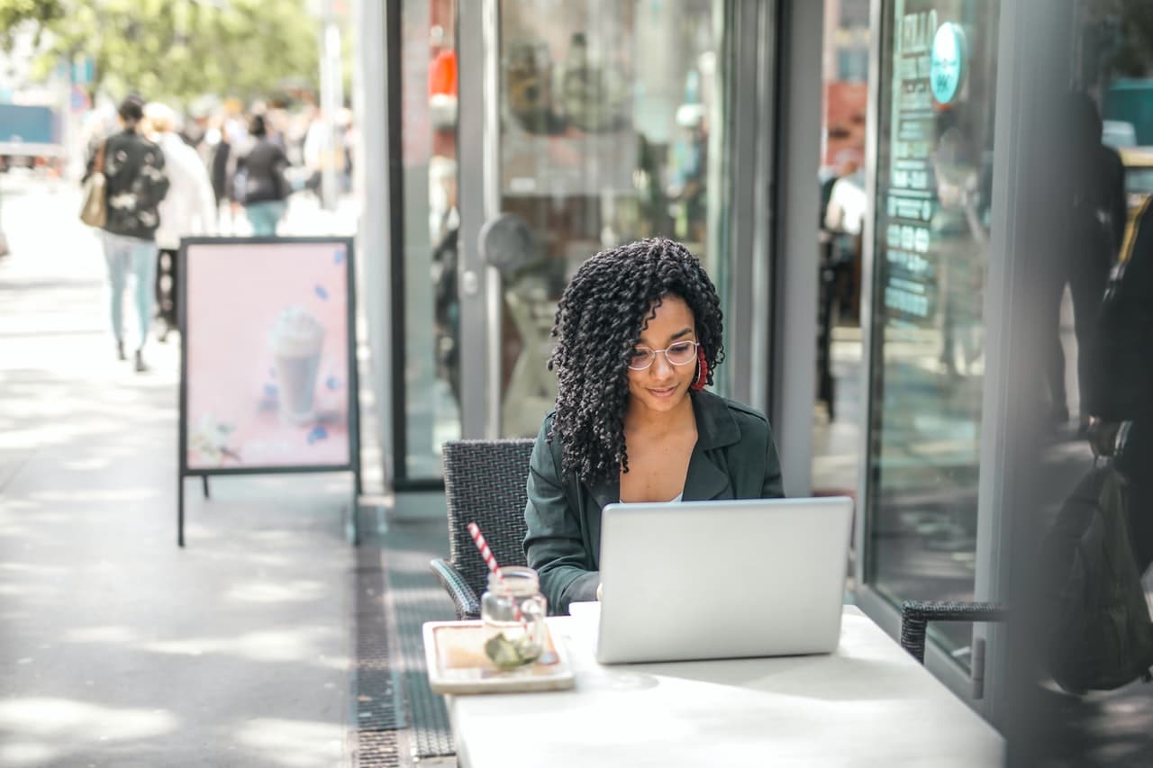 Woman browses e-commerce website on laptop outside