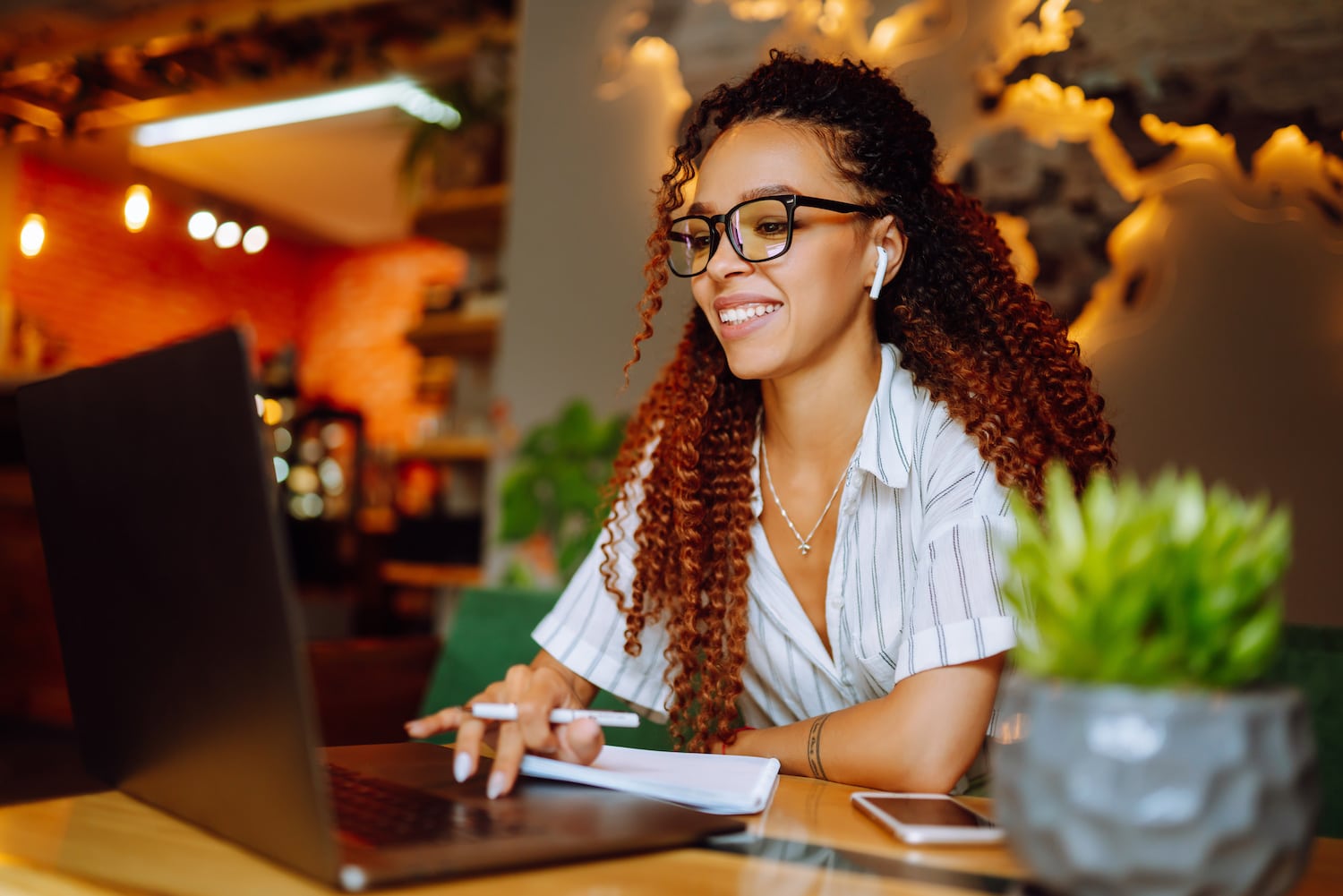 Woman wearing headphones calling on laptop