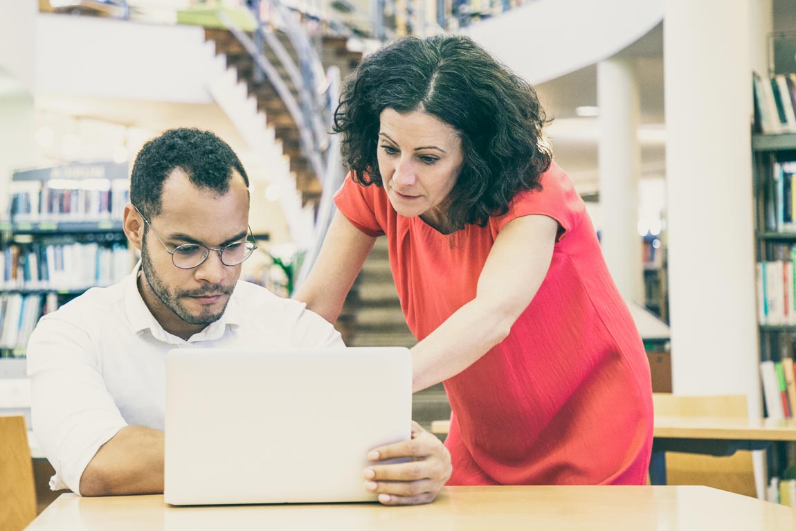 Two nonprofit coworkers look at filters on a laptop