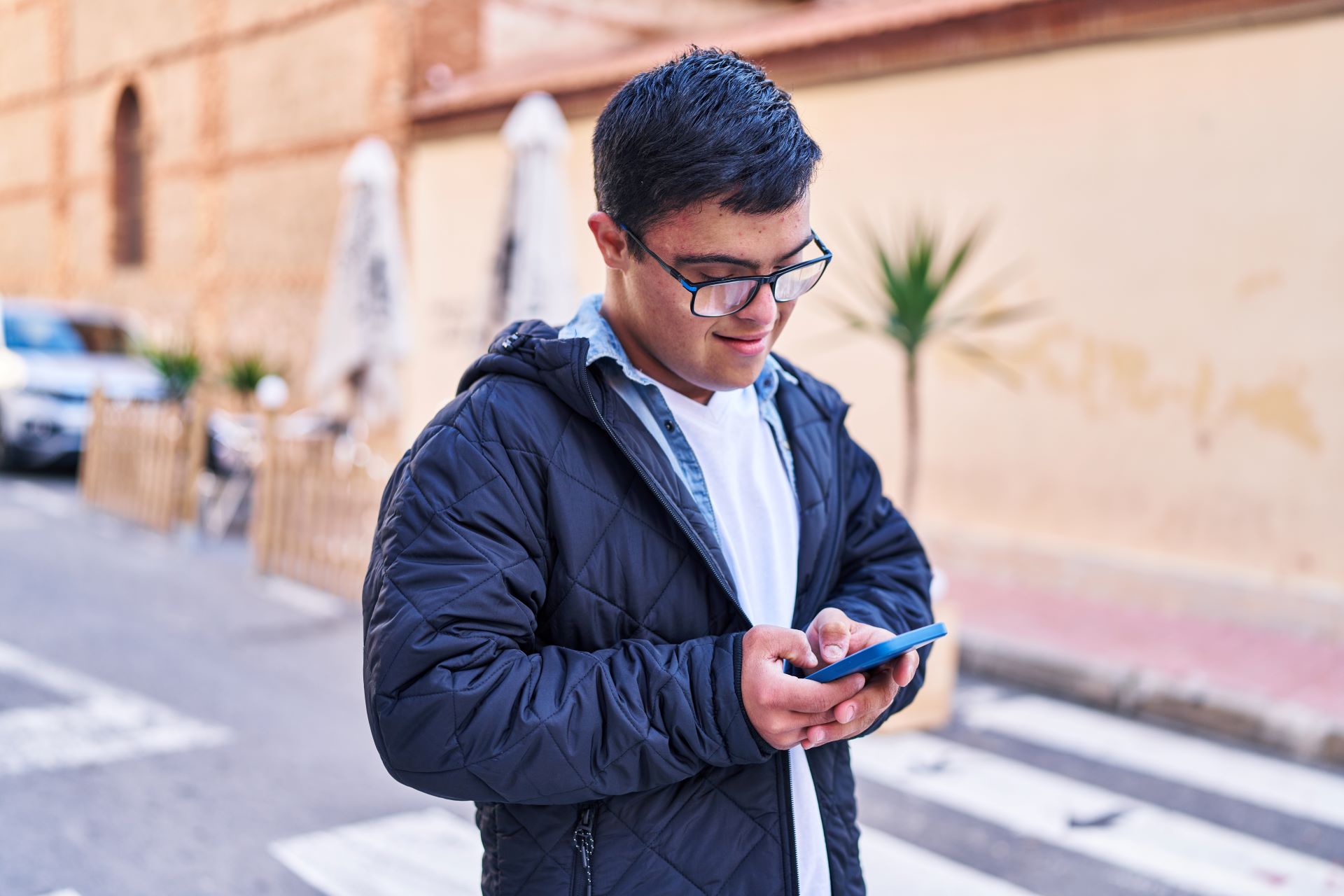 A young man uses a mobile phone to view Disability Rights Arizona's website