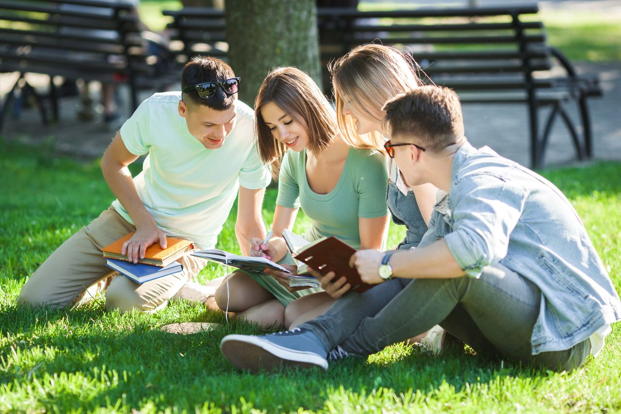Group of university students learning about website security on the grass.