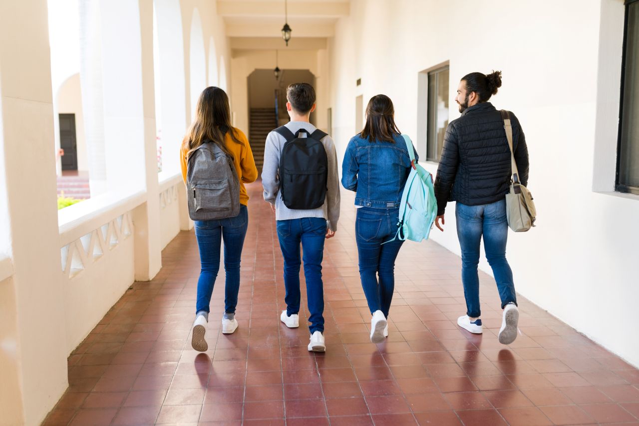 University students walk down a hallway after looking at scalable website.