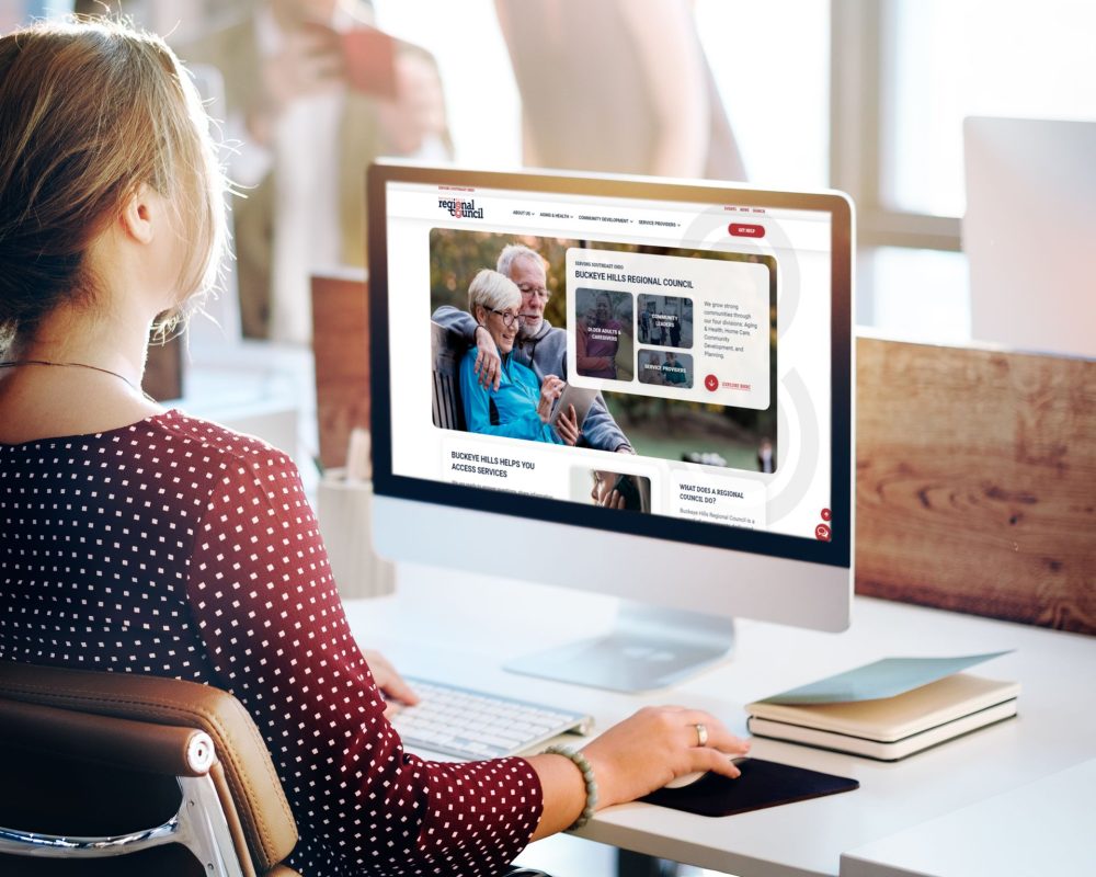 Woman at desk looking at Buckeye Hills Regional Council Desktop Mockup