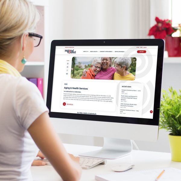 Woman at desk looking Buckeye Hills Regional Council Aging & Health Services page