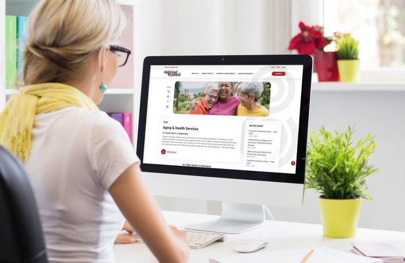 Woman at desk looking Buckeye Hills Regional Council Aging & Health Services page