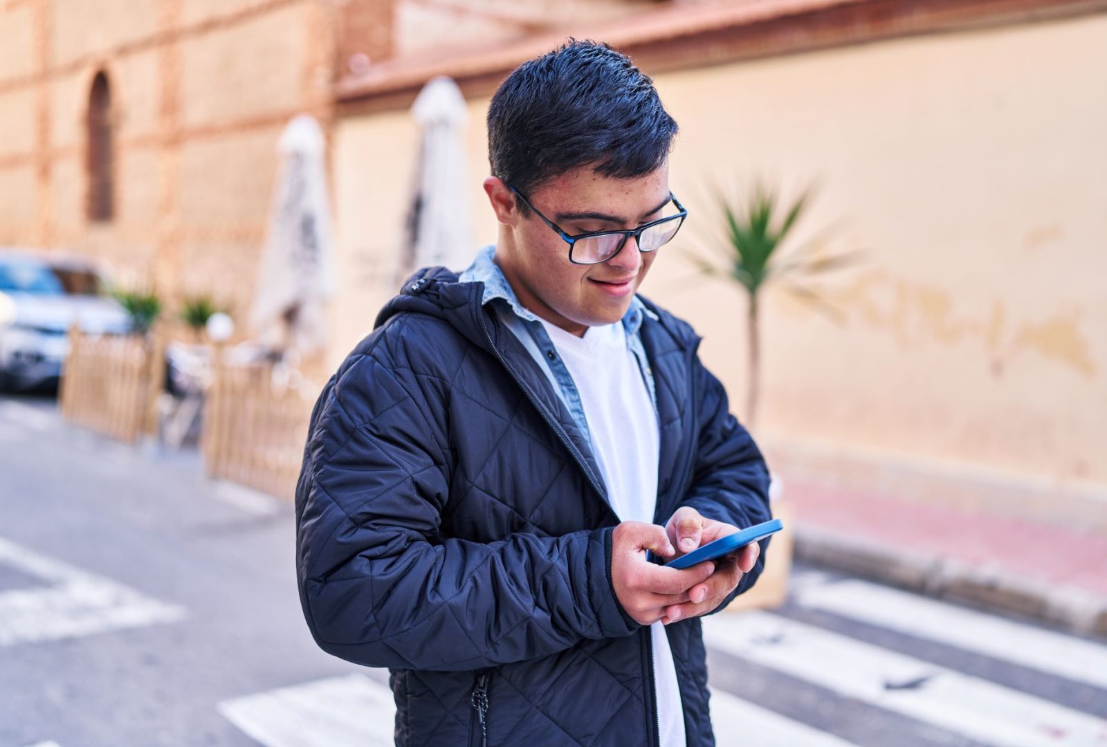 A young man uses a mobile phone to view Disability Rights Arizona's website